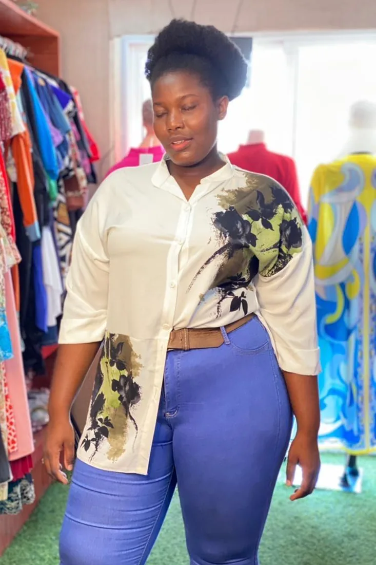 Before. Wuenam Glory before and after: in a cream floral-print blouse and jeans inside a clothing store, and in a blue satin blouse tied at the waist with jeans, against a plain wall.